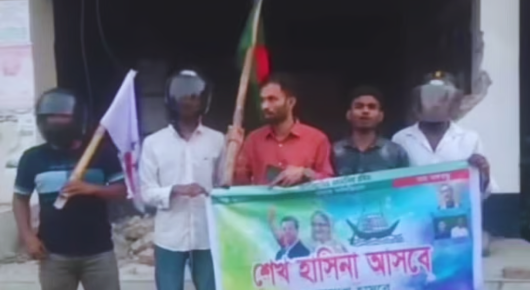 কার্যক্রম নিষিদ্ধ আওয়ামী লীগের ব্যানার ধরে আছেন কয়েকজন এবং একজনের হাতে জাতীয় ও আরেকজনের হাতে সাংগঠনিক পতাকা । ছবি: ভিডিও থেকে সংগৃহীত