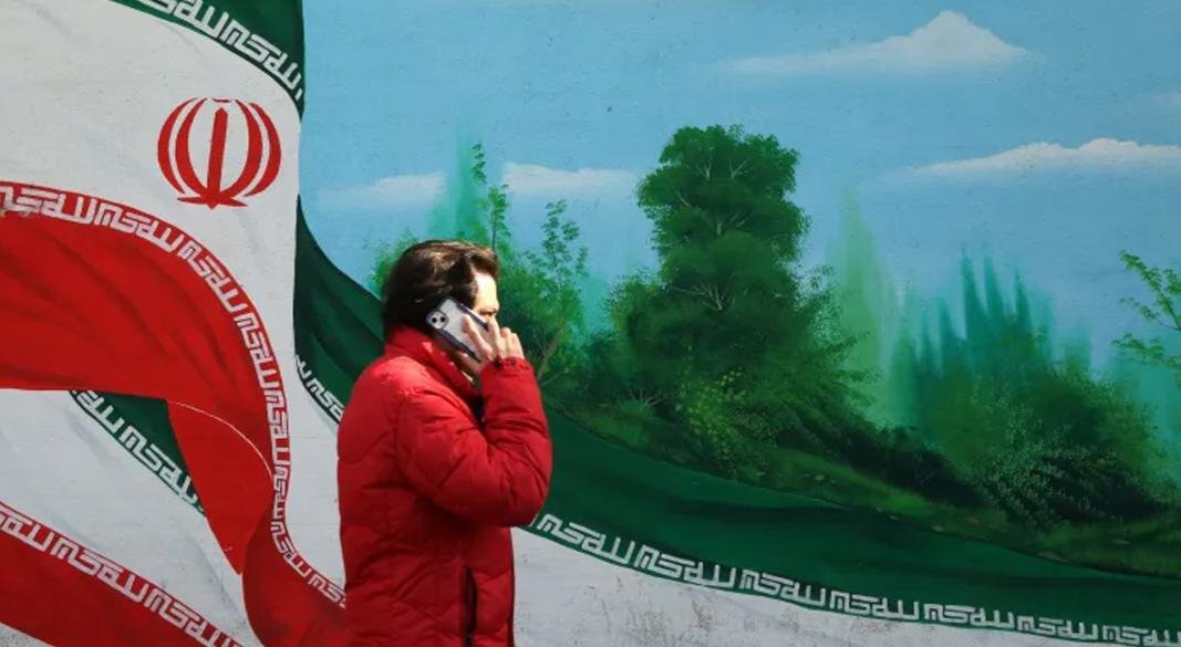 মার্কিন হামলার আশঙ্কার মাঝে ২৮ জানুয়ারি তেহরানে একজন ব্যক্তি দেয়ালচিত্রের পাশ দিয়ে হেঁটে যাচ্ছেন। ছবি: আনাদোলু