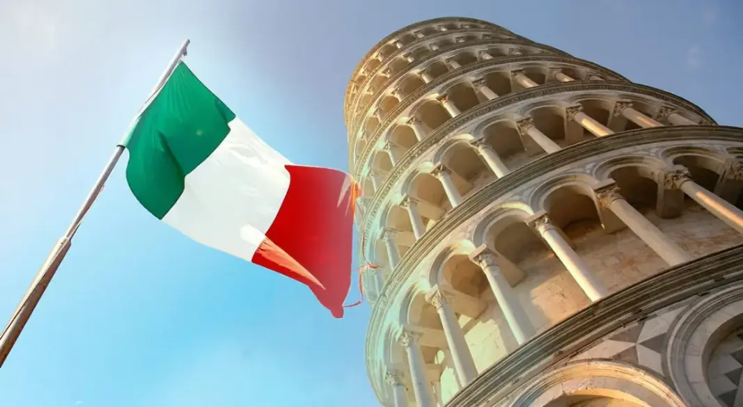 ইতালির বিখ্যাত পিসার হেলানো মিনার (Leaning Tower of Pisa) এবং এর পাশে বাতাসে উড়ন্ত ইতালির জাতীয় পতাকা দেখা যাচ্ছে। ছবি:সংগৃহীত